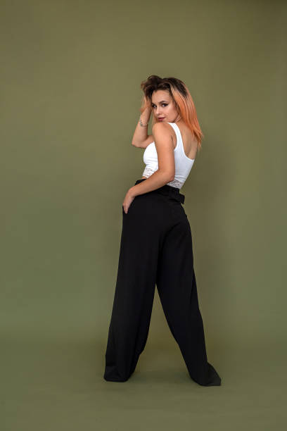 istock beautiful well-groomed woman posing boldly on a solid green studio background. 1392194476