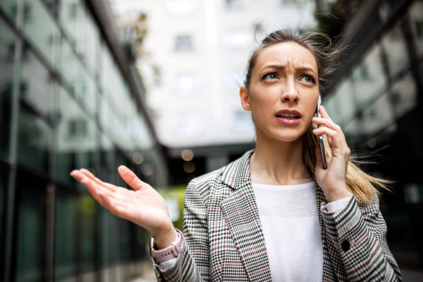 donna d'affari scontenta che usa il telefono - complaining foto e immagini stock