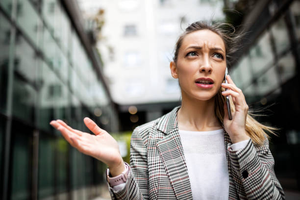 Displeased businesswoman using phone Worried angry businesswoman using phone complaining stock pictures, royalty-free photos & images