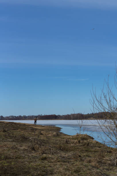 istock beautiful place, unknown man looking at nothing in a lake 1392198109