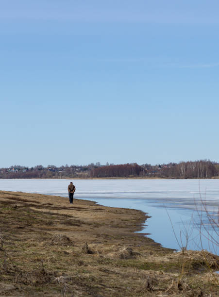 beautiful place, unknown man looking at nothing in a lake beautiful place, unknown man looking at nothing in a lake spirituality adventure searching tranquil scene stock pictures, royalty-free photos & images