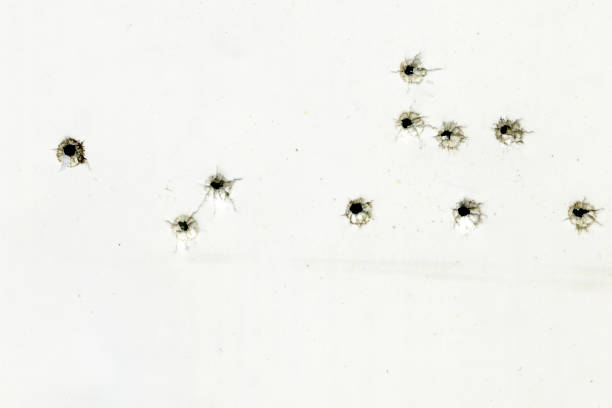 白い紙の上の弾痕、銃声による損傷 - bullet hole ストックフォトと画像