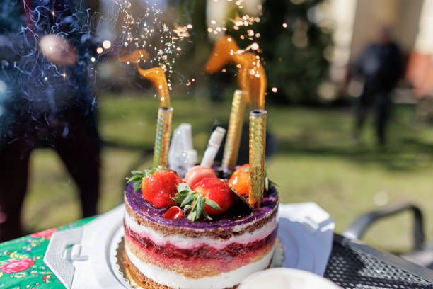 Birthday cake with sparklers in the back yard on a sunny day.\nCanon R5