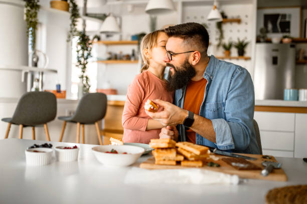 istock Sunday breakfast. Father and daughter having sweet waffles for breakfast. 1392201806