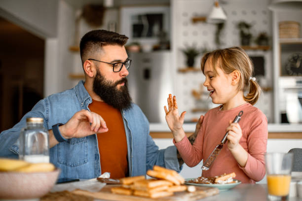 istock Father assisting to her daughter and helping her decorating waffles 1392201863