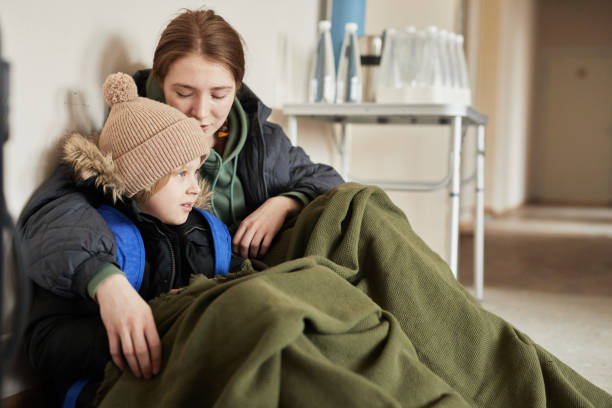 mère et fils dans un refuge pour réfugiés - abri anti bombe photos et images de collection