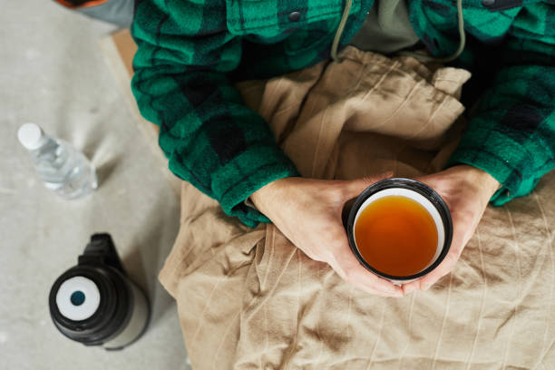 un réfugié tient une tasse de thé chaud - abri anti bombe photos et images de collection