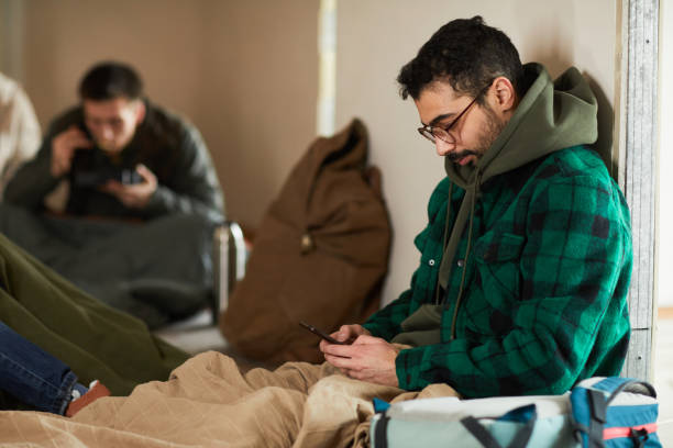 istock Man Texting Family in Shelter 1392201954