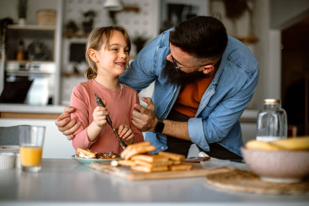 istock Father and daughter making and decorating waffles together. 1392202000