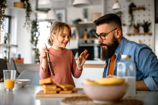 istock Father and daughter making and decorating waffles together. 1392202026
