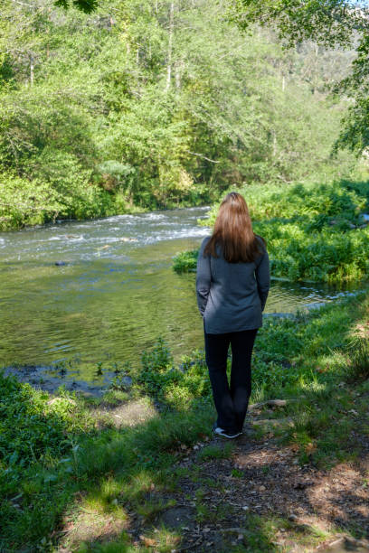 istock Woman in the woods by the river 1392205247