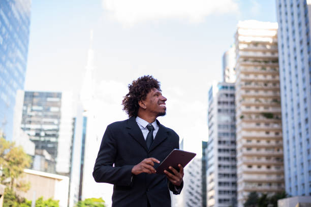 istock Brazilian man working and using technology in the city 1392205444