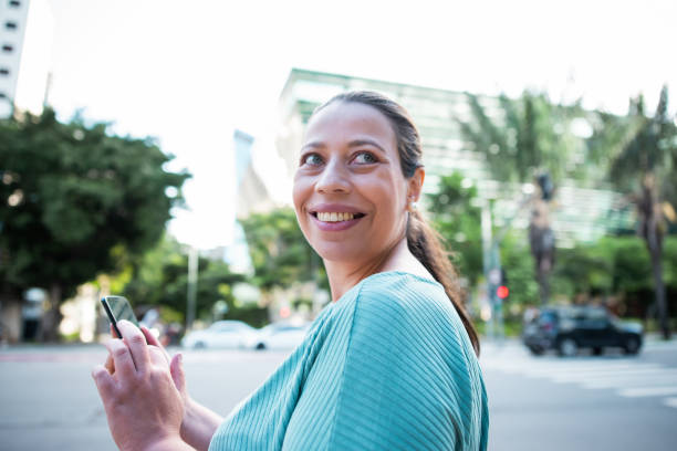 istock Brazilian woman working and using technology in the city 1392205550
