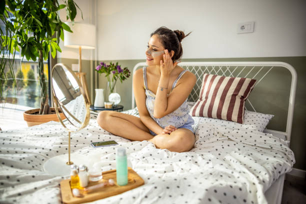 istock Smiling woman applying face cream 1392212529