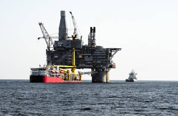 istock Oil rig offshore platform and support vessel. Gray blue sky, sea surface 1392215935