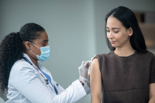 istock Doctor Preparing a Woman's Arm for Vaccination 1392216097