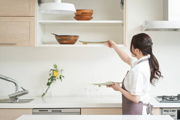 Asian woman organizing the kitchen Asian woman organizing the kitchen plate rack stock pictures, royalty-free photos & images