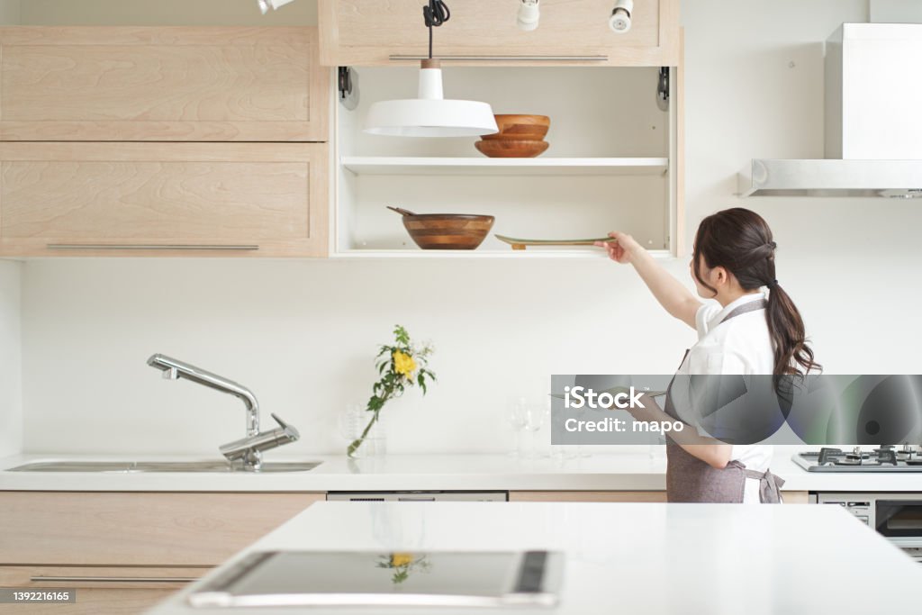 Asian woman organizing the kitchen Kitchen Stock Photo