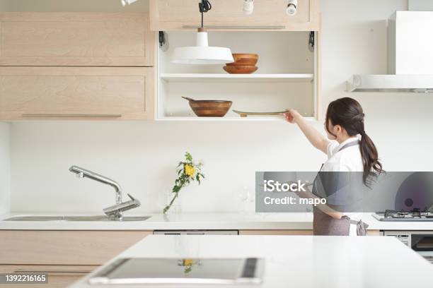 Asian Woman Organizing The Kitchen Stock Photo - Download Image Now - Kitchen, Decluttering, Organization
