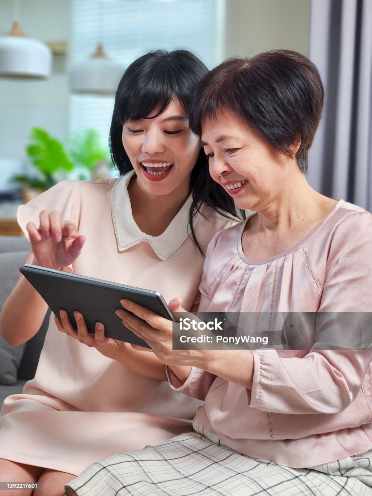 Filha mostrar tablet para a mãe - Foto de stock de Japonês royalty-free