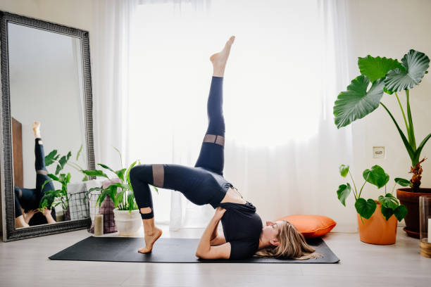 istock Young woman practicing yoga at home 1392218580