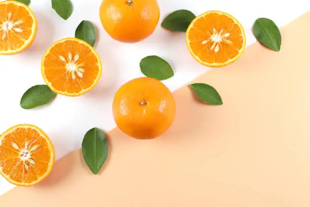 Photo of Flat decoration with fresh orange slices isolated from white background against orange background, high view.