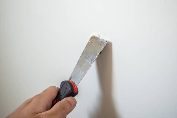 man repairing crack white wall with spatula - plasterer plaster wall dirty imagens e fotografias de stock