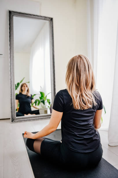 istock Women meditating in front of mirror 1392228181