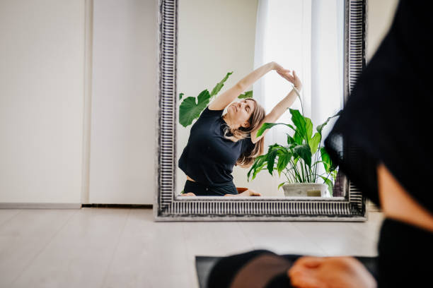 Women meditating in front of mirror
