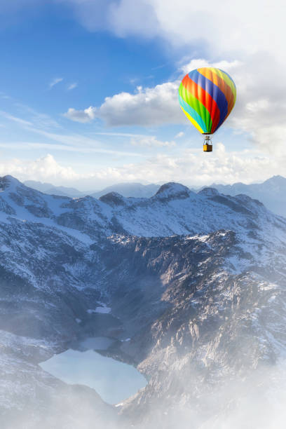 Dramatic Mountain Landscape covered in clouds and Hot Air Balloon Flying. 3d Rendering Adventure Dream Concept Artwork. Aerial Image from British Columbia, Canada.