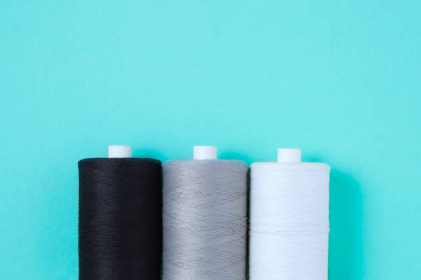 istock Three spools of sewing thread lie in  row. Place for text. Turquoise background. 1392230887