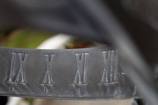 A closeup view of a metal sundial showing Roman numerals.
