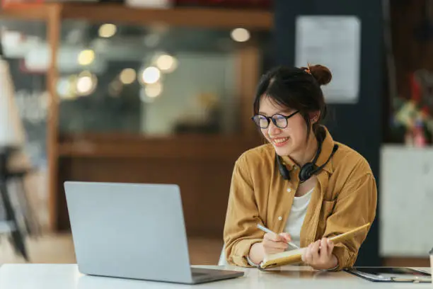 Photo of Asian girl student online learning class study online video call zoom teacher, Happy asian girl learn english language online with computer laptop.