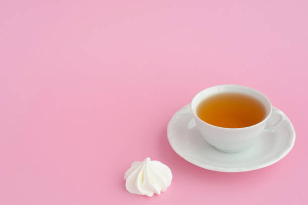 istock A cup of tea and marshmallows on a pink table background, copy space. Black tea and sweets, tea time 1392255557