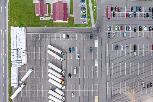 half empty parking lot near shopping center or farmers market. aerial overhead view.