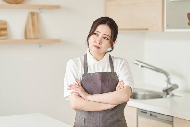 a woman in the housekeeping business who crosses her arms and thinks - estereótipo de dona de casa imagens e fotografias de stock