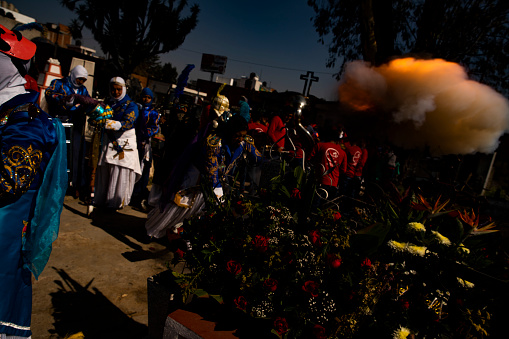 A general view shows a member detonating his carabiner and causing a ball of smoke on the grave of his already dead partner, prior to the carnival that will take place in the municipality of Cholula Puebla, on March 5, 2022 (Photo OZ / Octavio Sanchez)