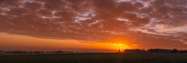 This beautiful Mountain mill is located in Wannegem-Lede Belgium, with the rise of the sun and  clouds.