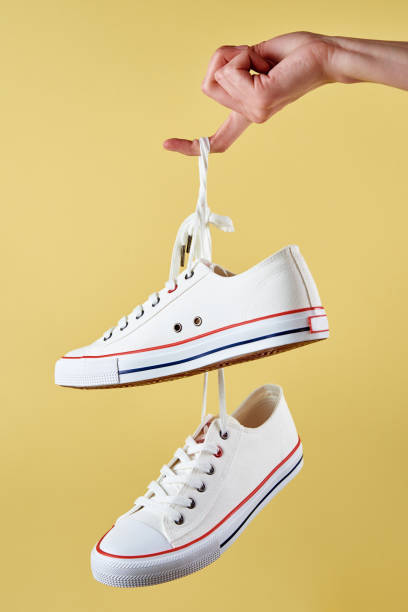 istock White casual sneakers on yellow background, creative minimalism 1392260281