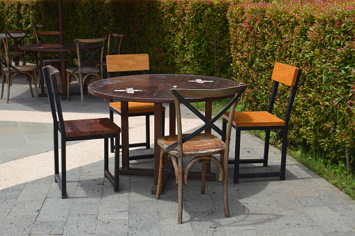 Empty Cafe Chairs And Tables In The Garden On Sunny Day