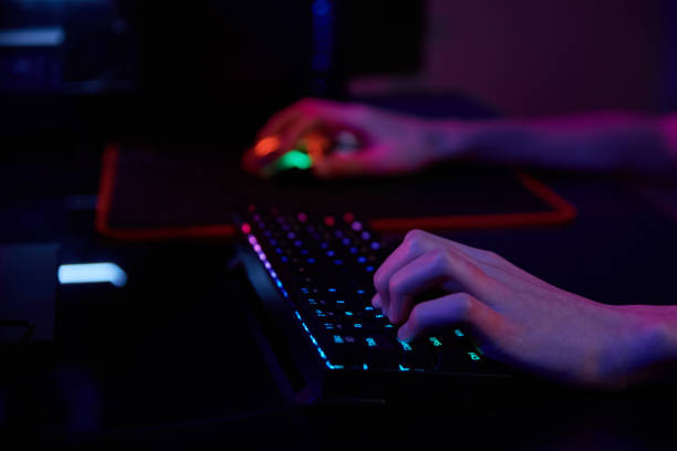 istock Gamer play computer game, use rgb neon colored keyboard 1392261267