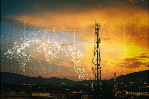 Telecommunication tower during sunset with HUD graphical internet worldwide connectivity of 3G, 4G and 5G network. Technology concept. Antenna, microwave, repeater, base station. Mobile communications.