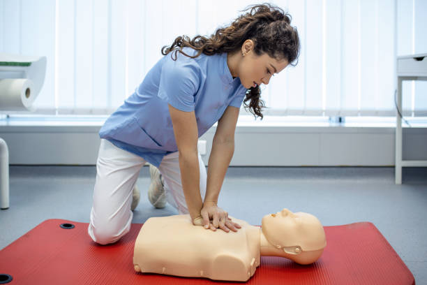 istock CPR class with instructors talking and demonstrating firt aid, compressions ans reanimation procedure. Cpr dummy 1392267103