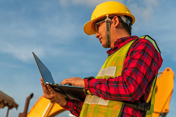 istock Asian engineers use walky talky with team for earthmoving project by excavator. foreman use laptop for construction project heavy digger. machinery and equipment for worker industrial. 1392271833