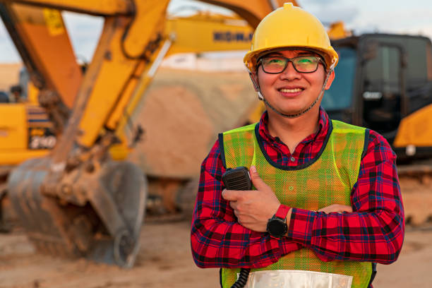 istock Asian engineers use walky talky with team for earthmoving project by excavator. foreman use laptop for construction project heavy digger. machinery and equipment for worker industrial. 1392271873
