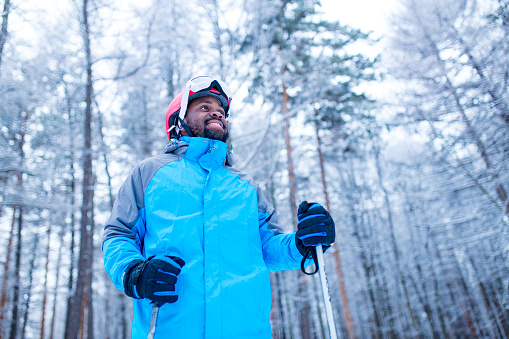 latin american young skier man forest winter day in New Year holidays Christmas .