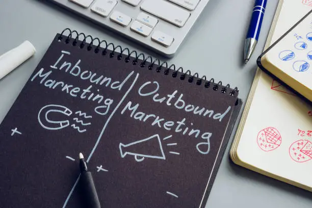 Inbound and outbound marketing pros and cons in a notepad.