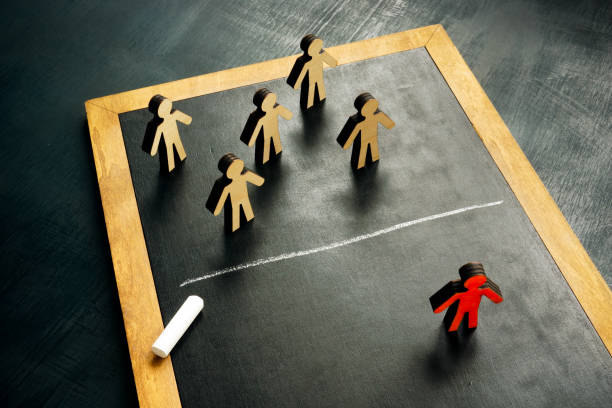 istock Social exclusion concept. Figurines and a chalk line separating them. 1392274664