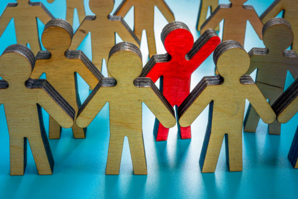 istock Be different and leader concept. A crowd of figurines and one red. 1392274688