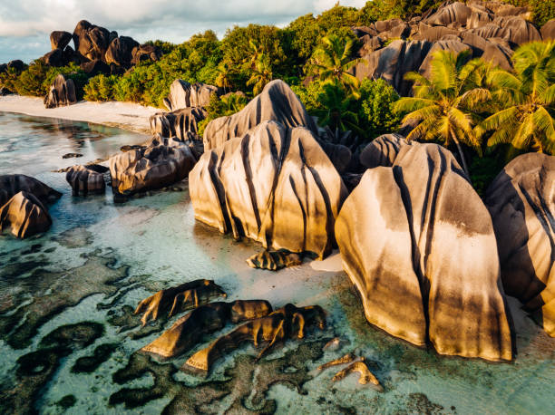 Anse Source d'Argent Beach La Digue Island Seychelles La Digue Anse Source d'Argent Beach. Drone view over the famous Anse Source d'Argent Beach with it’s famous granite boulder rock formations and crystal clear ocean on La Digue Island in warm sunset light. La Digue Island, Seychelles Islands, East Africa la digue island photos stock pictures, royalty-free photos & images